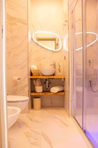 bagno con doccia, lavandino e specchio di BelMa' Aparthotel and Rooms a Marina di Camerota