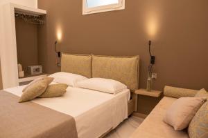 a bedroom with two beds with white sheets and pillows at BelMa' Aparthotel and Rooms in Marina di Camerota