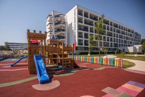 a playground in front of a large building at Hotel Terra in Neptun