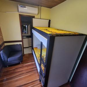 a bunk bed in a tiny house with a blue chair at COYOTE POUSADA&HOSTEL in Foz do Iguaçu