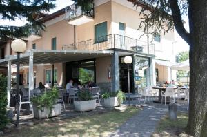 people sitting at tables outside of a building at Green Village Accommodations in Colico