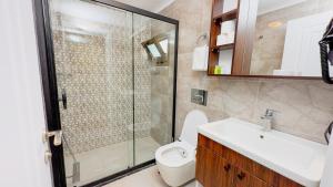 a bathroom with a shower and a toilet and a sink at Feri Surf Club Hotel Datça in Datca