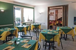 a dining room with green tables and yellow tablecloths at Green Village Accommodations in Colico