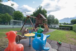 a playground with toy animals and a swing at Green Village Accommodations in Colico