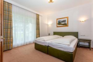 a bedroom with a bed and a large window at Berghof-Chalet in Erpfendorf