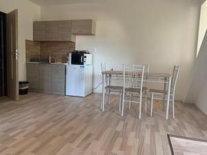 uma cozinha com uma mesa e cadeiras e um frigorífico em Apartmány JG Patince em Patince