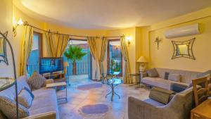 a living room with a couch and a tv at Villa Funda Apart in Kalkan