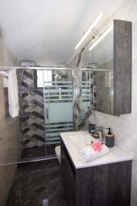 een badkamer met een wastafel en een douche bij angelastudios-stoupa in Stoupa