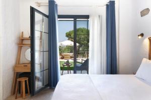 a bedroom with a bed and a view of a patio at Armel Alaçatı in Alacati