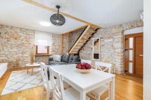 cocina y sala de estar con mesa blanca y sillas en Stone house Istria en Pula