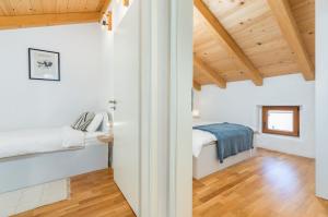 1 dormitorio con paredes blancas y techos de madera en Stone house Istria en Pula