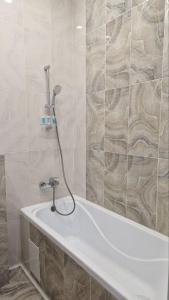 La salle de bains est pourvue d'une baignoire et d'une douche. dans l'établissement Апартаменты в ЖК Bi city TOKYO, à Astana