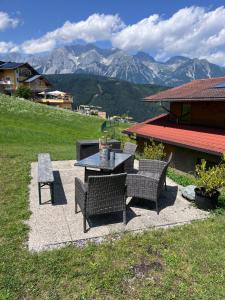 a patio with a table and chairs and mountains at Apartment Alpenperle in Schladming