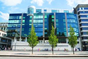 un grand bâtiment en verre avec des arbres devant lui dans l'établissement Luxury Apartment Liverpool heart of city center Close to Arena, à Liverpool