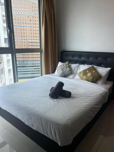 una bata negra puesta en una cama con ventana en Regalia Modern Studio, en Kuala Lumpur