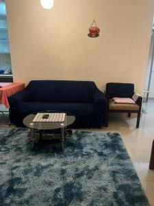 sala de estar con sofá azul y mesa en Regalia Modern Studio, en Kuala Lumpur