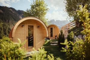 ein kleines Holzgebäude mit einer Tür im Gras in der Unterkunft Ostí Vedl in St. Martin in Thurn