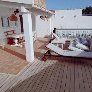 una terrazza con cuscini e tavoli su una casa di Gorgeous Beach Villla with AC, 300m2 from Playa Mitjorn a Playa Migjorn
