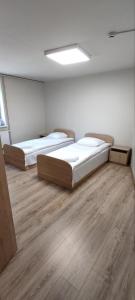 twee bedden in een grote kamer met houten vloeren bij Trevena Kretinga in Kretinga