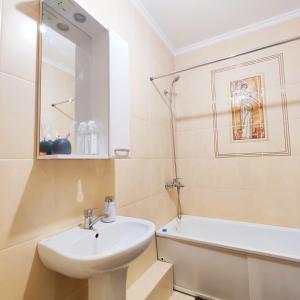ein Badezimmer mit Waschbecken und Badewanne in der Unterkunft EmmaApart Comfort 110 in Astana
