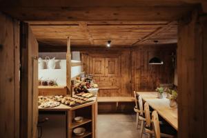 a kitchen with wooden walls and a long table with chairs at Ostí Vedl in San Martino in Badia