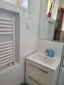 W białej łazience znajduje się umywalka i lustro. w obiekcie Nartorama HotRest w Zieleńcu