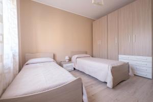 a bedroom with two beds and a cabinet at Damilhouse 4 in Messina