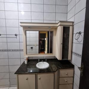 a bathroom with a sink and a mirror at COYOTE POUSADA&HOSTEL in Foz do Iguaçu