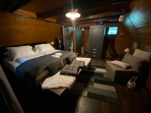 ビハチにあるVikendica Bellaのベッドルーム(大型ベッド1台、ソファ付)