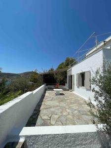 a patio with a bench on a white building at Attica Vacation Home in Dhaskalión