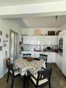 a kitchen with a table and chairs in a room at Attica Vacation Home in Dhaskalión