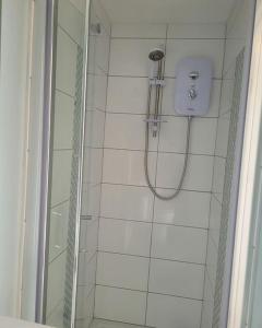 um chuveiro com uma porta de vidro na casa de banho em Abeen Atlantic em Portstewart