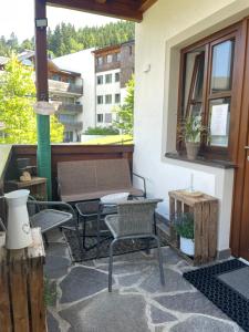 un patio con sillas, una mesa y una ventana en Luserblick, en Haus im Ennstal