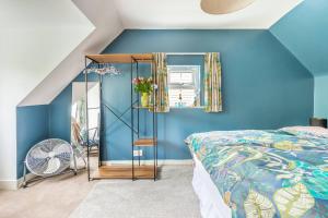 Dormitorio azul con cama y espejo en Room in Guest room - Calm For 3, Handy For Airporttrain Free Parking, en Bishops Stortford