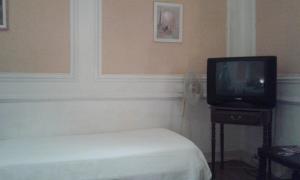 リスボンにあるカーサ デ オスペデス ボア ノイテのベッドルーム(ベッド1台、テーブル上のテレビ付)