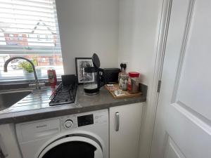 a kitchen with a washing machine and a sink at Barry Waterfront Stays - ENTIRE 3 BED PROPERTY in Barry