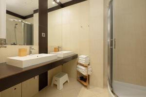a bathroom with two sinks and a shower at Pine House by Sea in Pobierowo