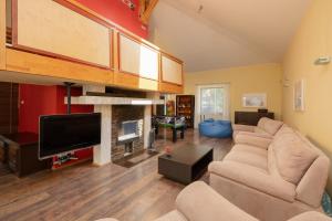 a living room with a couch and a flat screen tv at Pine House by Sea in Pobierowo