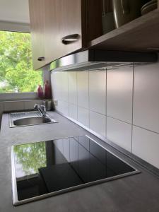 een keuken met witte kasten, een wastafel en een raam bij House of hanover in Hannover
