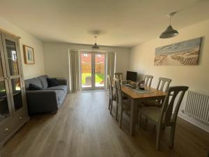 a living room with a table and a couch at Barry Waterfront Stays - ENTIRE 3 BED PROPERTY in Barry