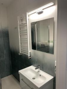 a bathroom with a sink and a mirror at Apartament Boston Jastrzębia Góra in Jastrzębia Góra
