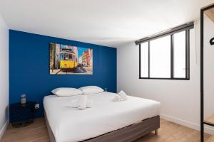 um quarto com uma cama branca e uma parede azul em DIFY Mazenod - Prefecture em Lyon