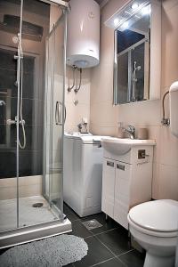 uma casa de banho com um chuveiro, um WC e um lavatório. em Novobeogradska priča em Belgrado