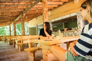 Dos mujeres sentadas en una mesa en un restaurante en Vucja Gora, en Foča