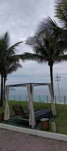 Cama con dosel y palmeras en la playa en Hotel Nacional Rio de Janeiro, en Río de Janeiro