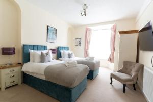 a hotel room with two beds and a chair at Room 1, Hotel style twin bedroom in Marazion in Marazion