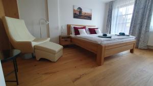 1 dormitorio con 1 cama y 1 silla en Wellness apartmán Pila na Kvildě en Kvilda