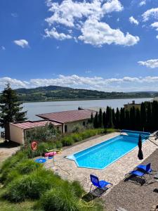 a swimming pool with chairs and a view of a lake at Przystań Znamirowice in Znamirowice