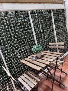 Drewniana ławka z doniczkową rośliną przy ścianie w obiekcie Wonder Nerja Paraiso Apartamento w mieście Nerja
