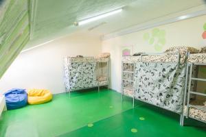 a room with two bunk beds and a green floor at Lucky Hostel на Крещатике in Kyiv
